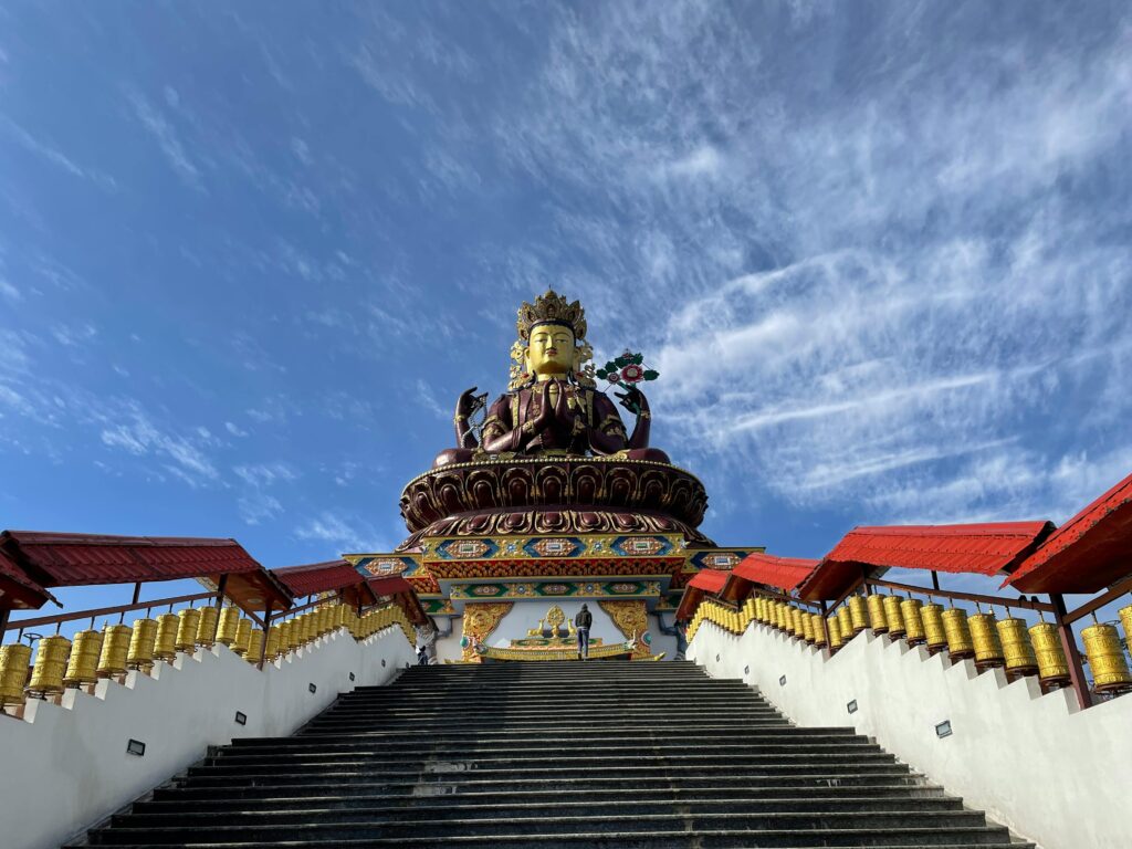 Majestic Maitreya Buddha statue under a clear blue sky in Pelling, Sikkim.